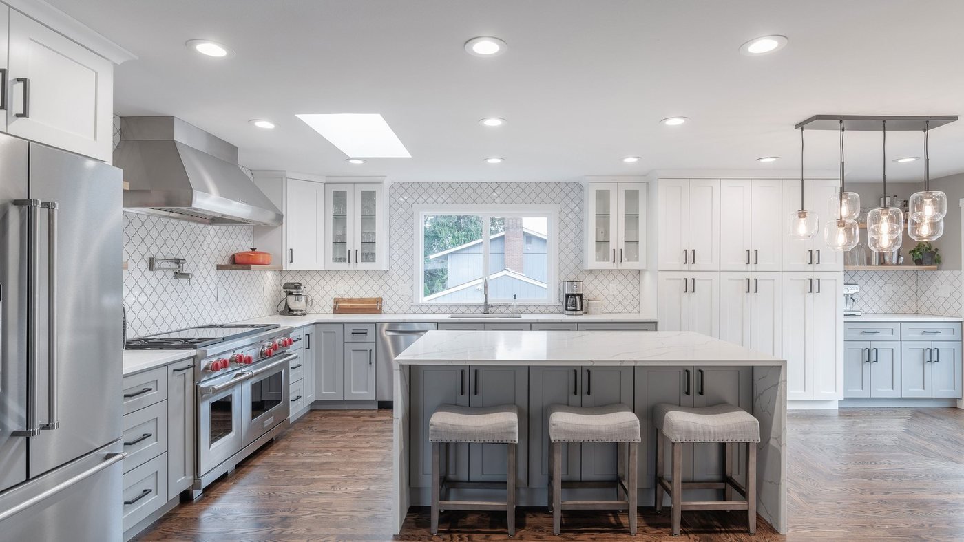 Remodeled kitchen with an island, counter stools, and warm wood flooring
