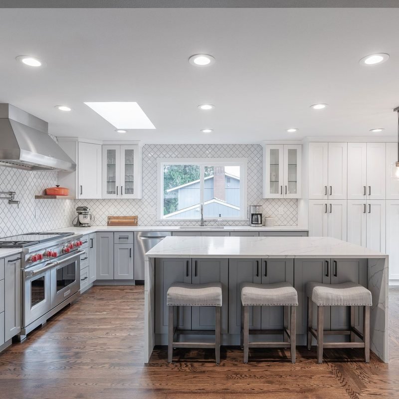 Remodeled kitchen with an island, counter stools, and warm wood flooring