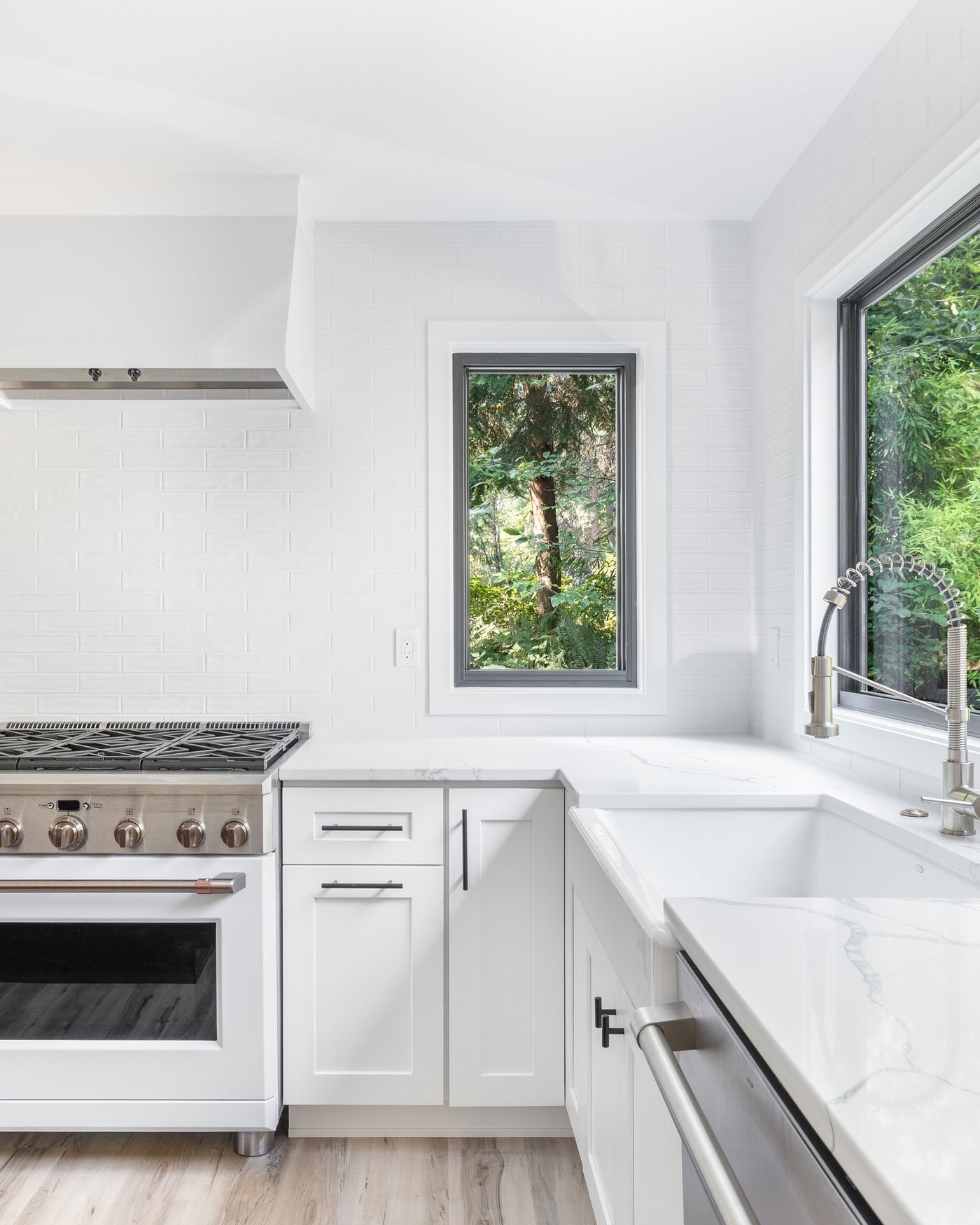 Kitchen with a professional range, marble style counters, and a large window