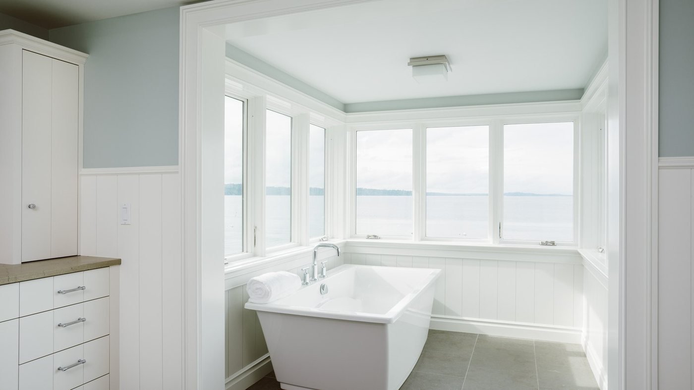 Remodeled bathroom with a freestanding soaking tub by a window