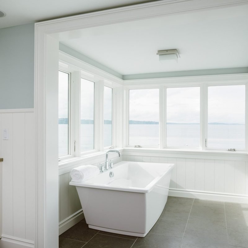 Remodeled bathroom with a freestanding soaking tub by a window