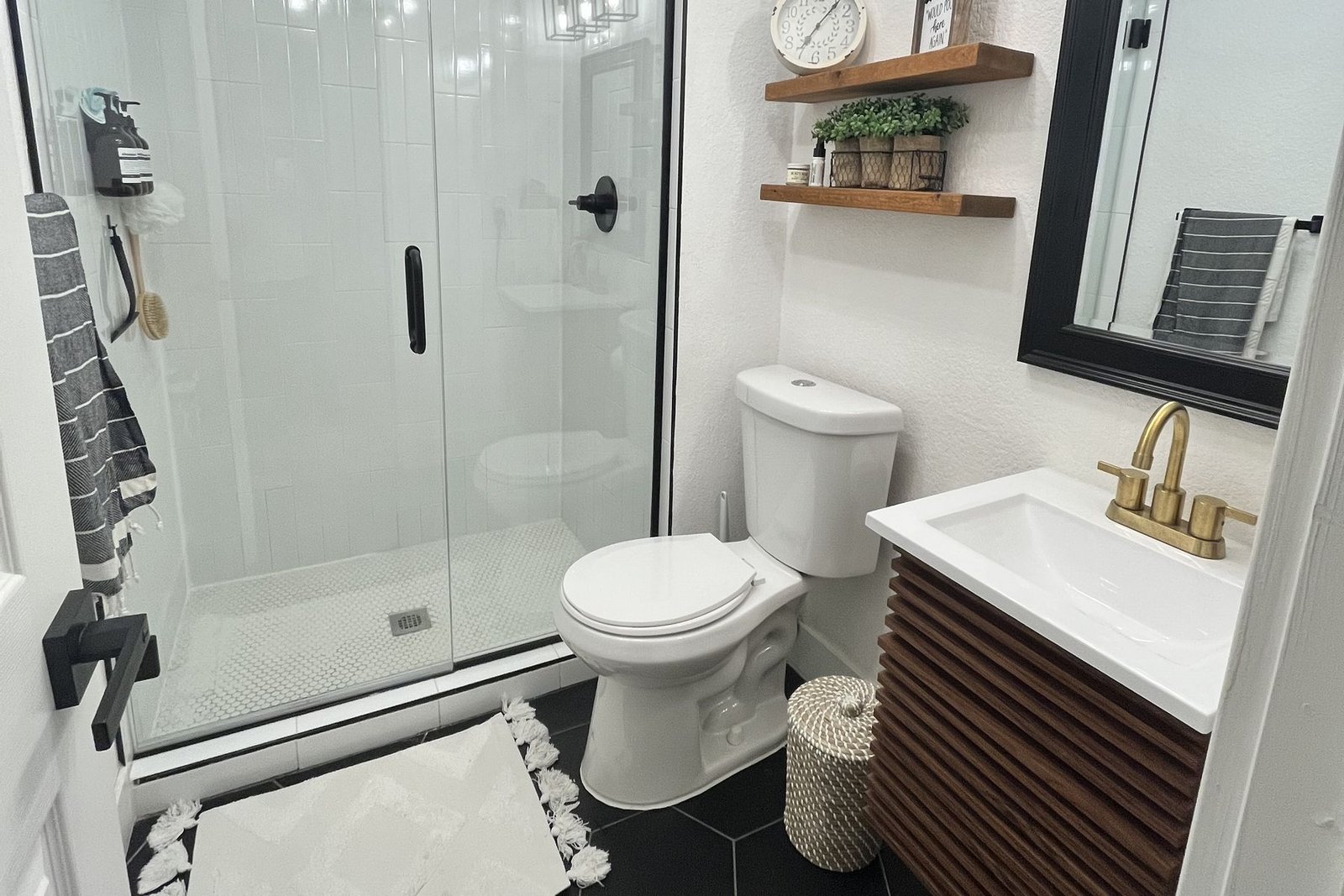 A walk in shower lined in travertine, open to a window with a long view