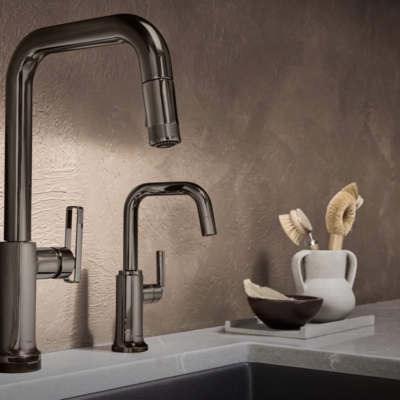 Two brushed metal kitchen faucets, a tall gooseneck and a lower pot filler, over an undermount sink