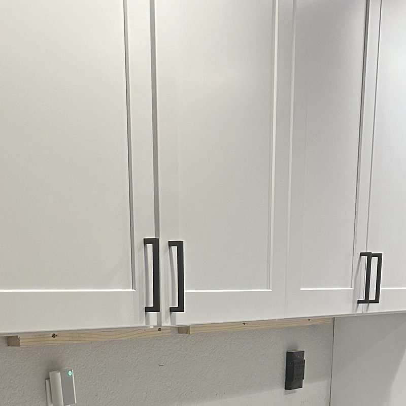 Matte black bar pulls on white shaker cabinet doors