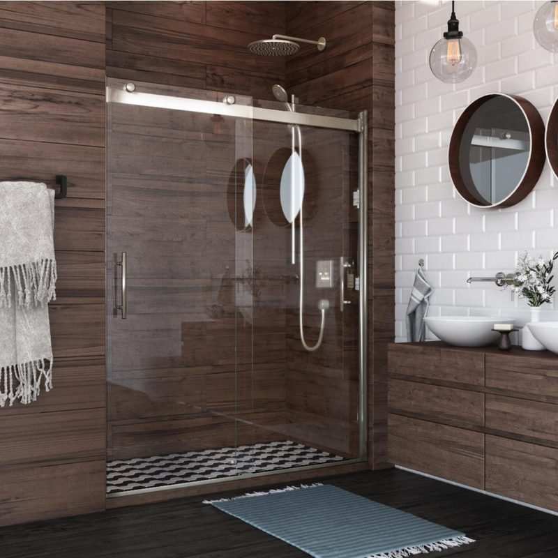A walk in shower behind a sliding glass door, lined in wood look tile beside a white subway tile wall